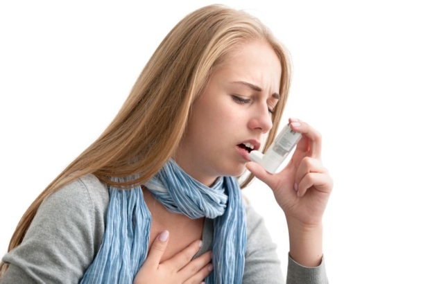 21817831 - young woman using an asthma inhaler as prevention