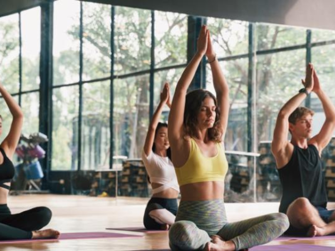 mujeres-practicando-yoga-en-el-gimnasio