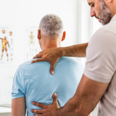 Male Doctor and patient suffering from back pain during medical exam