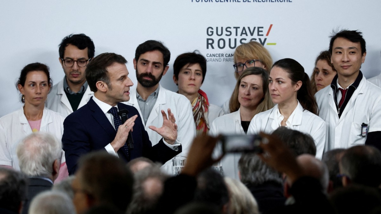 French President Emmanuel Macron (3rdL) delivers a speech during a ceremony to lay the first stone of the future research center as part of a visit at the Gustave Roussy Institute (IGR), a regional centre for the fight against cancer, on the occasion of World Cancer Day, in Villejuif, near Paris, on February 4, 2025. (Photo by Benoit Tessier / POOL / AFP)