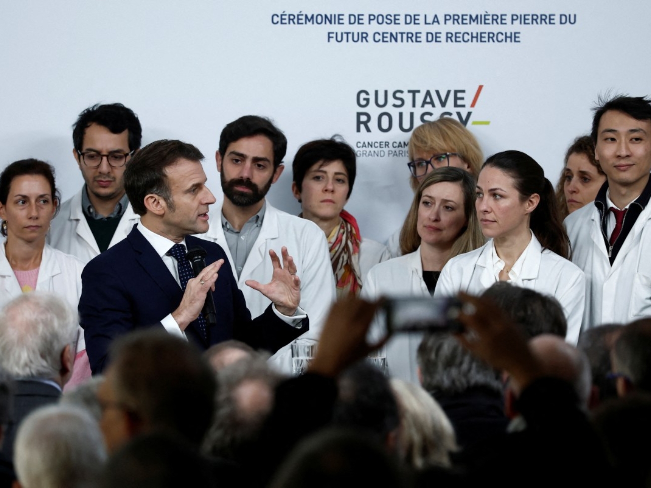 French President Emmanuel Macron (3rdL) delivers a speech during a ceremony to lay the first stone of the future research center as part of a visit at the Gustave Roussy Institute (IGR), a regional centre for the fight against cancer, on the occasion of World Cancer Day, in Villejuif, near Paris, on February 4, 2025. (Photo by Benoit Tessier / POOL / AFP)