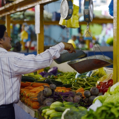 A man weighs vegetables at a popular market in Caracas on October 24, 2013. Venezuela, which is highly dependent on basic commodity imports, will massively boost its food and basic supplies imports in the next two months to counter shortages and high inflation, Vice president for the economy Rafael Ramirez said Wednesday. Since President Nicolas Maduro took office on April 19, Venezuela has seen a cyclical increase in shortages of sugar, coffee, oil, milk and toilet paper, among other products. Meanwhile, annual inflation in September soared to 49.4 percent, the highest in the past 13 years, according to official data.
 AFP PHOTO / JUAN BARRETO (Photo by JUAN BARRETO / AFP)