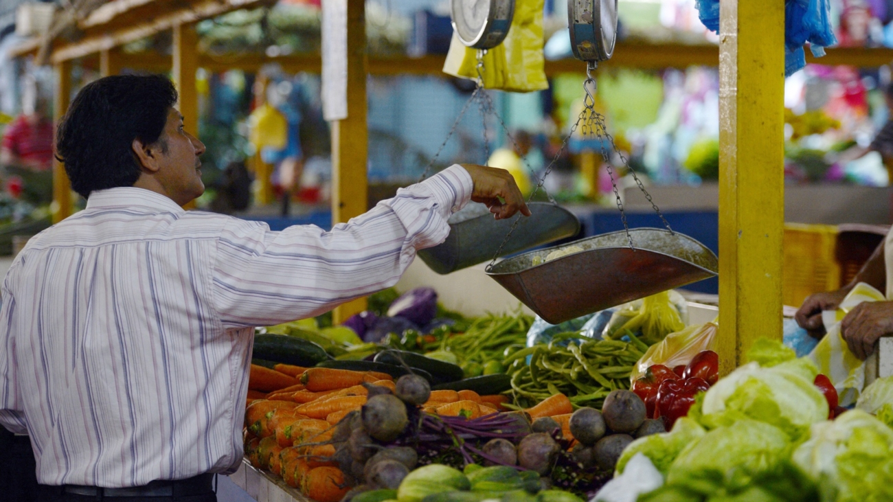 A man weighs vegetables at a popular market in Caracas on October 24, 2013. Venezuela, which is highly dependent on basic commodity imports, will massively boost its food and basic supplies imports in the next two months to counter shortages and high inflation, Vice president for the economy Rafael Ramirez said Wednesday. Since President Nicolas Maduro took office on April 19, Venezuela has seen a cyclical increase in shortages of sugar, coffee, oil, milk and toilet paper, among other products. Meanwhile, annual inflation in September soared to 49.4 percent, the highest in the past 13 years, according to official data.
 AFP PHOTO / JUAN BARRETO (Photo by JUAN BARRETO / AFP)