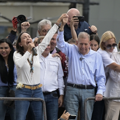 Venezuelan opposition leader Maria Corina Machado (L) talks to supporters as she rises the hand of opposition presidential candidate Edmundo Gonzalez Urrutia during a rally in front of the United Nations headquarters in Caracas on July 30, 2024. Venezuela braced for new demonstrations on July 30, after four people died and dozens were injured when the authorities broke up protests against President Nicolas Maduro's claim of victory in the country's hotly disputed weekend election. (Photo by Yuri CORTEZ / AFP)