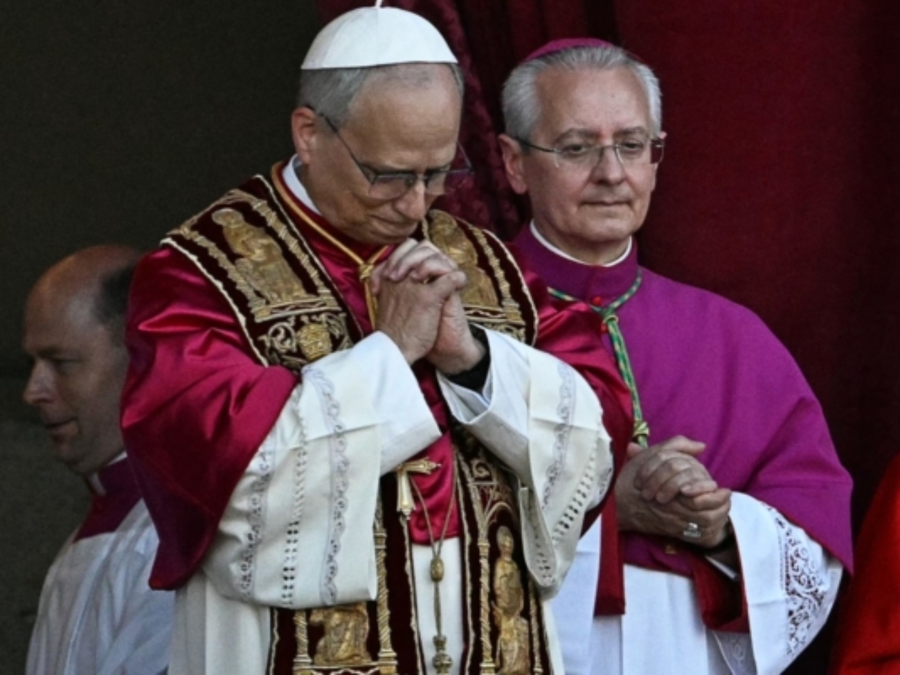 Newly elected Pope Leo XIV, Robert Francis Prevost (C) gestures as he addresses the crowd from the main central loggia balcony of the St Peter's Basilica for the first time, after the cardinals ended the conclave, in The Vatican, on May 8, 2025. Robert Francis Prevost was on Thursday elected the first pope from the United States, the Vatican announced. A moderate who was close to Pope Francis and spent years as a missionary in Peru, he becomes the Catholic Church's 267th pontiff, taking the papal name Leo XIV. (Photo by Gabriel BOUYS / AFP)