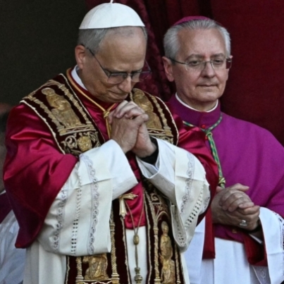 Newly elected Pope Leo XIV, Robert Francis Prevost (C) gestures as he addresses the crowd from the main central loggia balcony of the St Peter's Basilica for the first time, after the cardinals ended the conclave, in The Vatican, on May 8, 2025. Robert Francis Prevost was on Thursday elected the first pope from the United States, the Vatican announced. A moderate who was close to Pope Francis and spent years as a missionary in Peru, he becomes the Catholic Church's 267th pontiff, taking the papal name Leo XIV. (Photo by Gabriel BOUYS / AFP)