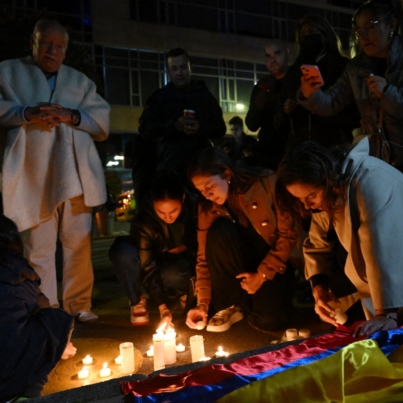 People light candles outside the Clinic Fundación Santa Fe, where Senator Miguel Uribe Turbay is receiving medical treatment after being shot and wounded in Bogota on June 7, 2025. A Colombian right-wing opposition senator and candidate for next year's presidential election, Miguel Uribe Turbay, 39, was shot and wounded in Bogota on June 7, 2025, various media reported, while the government denounced an "attack." (Photo by Raul ARBOLEDA / AFP)